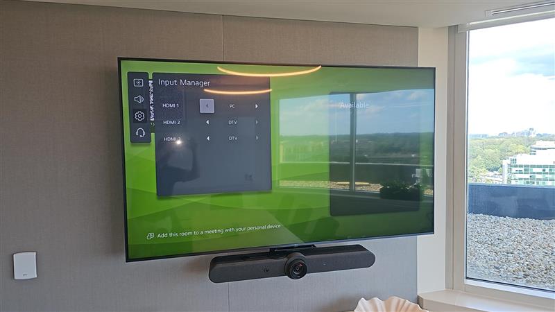 Wall-mounted display with Logitech camera bar - AV system installation